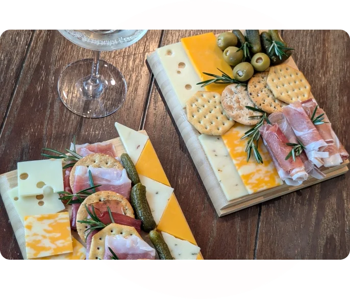 A wooden table with two trays of food on it.