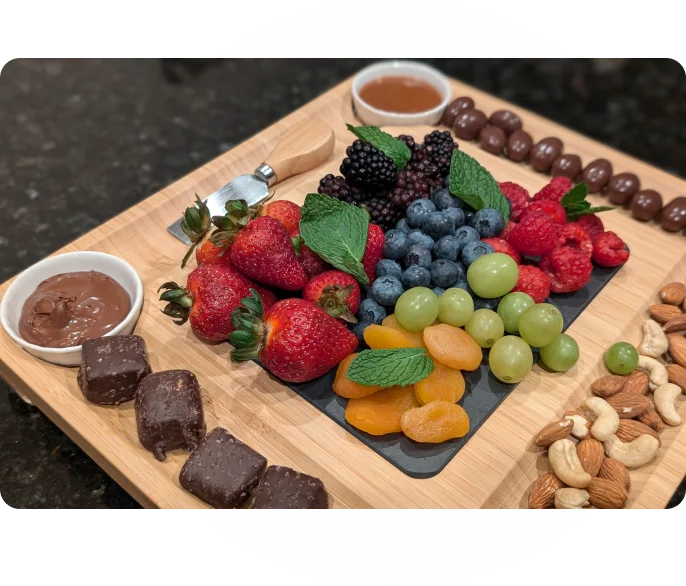 A wooden board with various fruits and nuts on it.